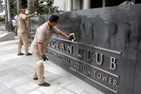 A worker cleans the site where the Trump name was removed from the Trump Ocean Club International Hotel and Tower in Panama City, Panama, March 5, 2018. PHOTO BY REUTERS/Carlos Lemos