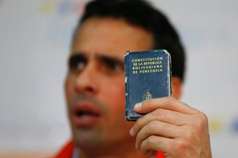 Venezuelan opposition leader and Governor of Miranda state Henrique Capriles holds a copy of the Venezuelan constitution while he talks to the media during a news conference in Caracas, Venezuela June 10, 2016. PHOTO BY REUTERS/Ivan Alvarado