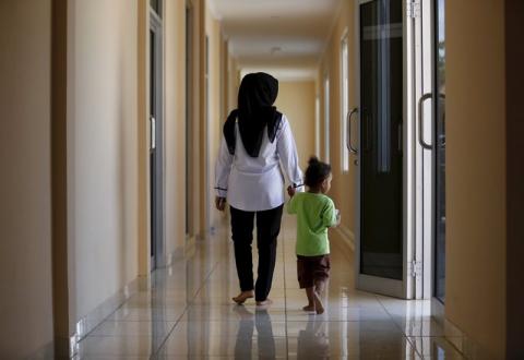 A counsellor and a recently rescued child walk together inside a state-run rehabilitation centre in Jakarta, Indonesia, April 4, 2016. PHOTO BY REUTERS/Darren Whiteside