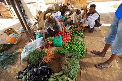 Customers look on as a vender displays fresh produce in Khartoum, Sudan December 2, 2016. PHOTO BY REUTERS/Mohamed Nureldin Abdallah