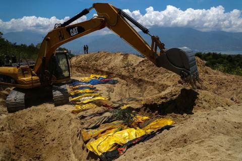Sand is placed over dead bodies of the victims of the earthquake and tsunami during a mass burial at the Poboya Cemetery in Palu, Central Sulawesi, Indonesia, October 2, 2018. PHOTO BY REUTERS/Athit Perawongmetha