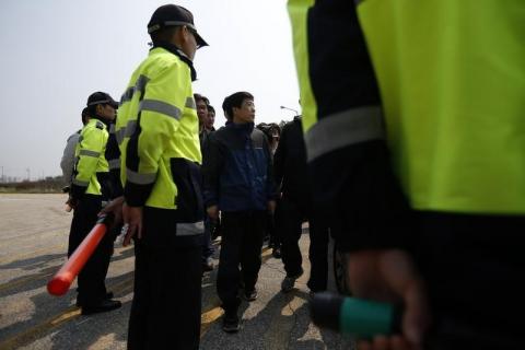 Park Sang-Hak (C), a North Korean defector living in the South and leader of an anti-North Korea civic group, walks past South Korean police officers, near the demilitarized zone which separates the two Koreas, in Paju, north of Seoul, May 4, 2013. PHOTO BY REUTERS/Kim Hong-Ji