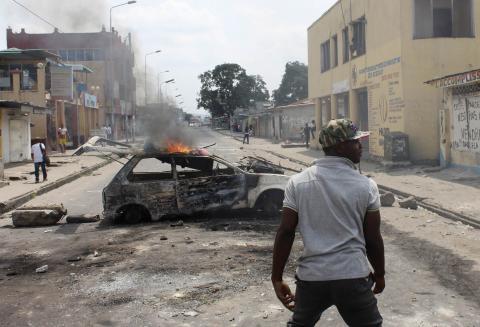 A demonstrator walks near a car set ablaze to barricade a street during a protest in the Democratic Republic of Congo's capital Kinshasa, January 20, 2015. PHOTO BY REUTERS/Jean Robert N'Kengo