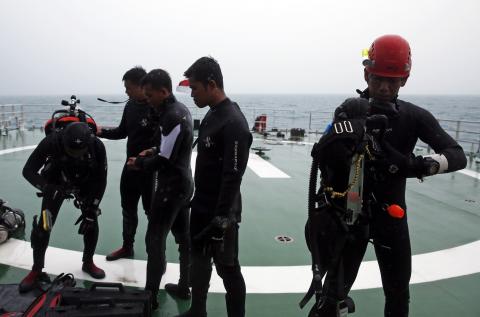 A group of divers prepares their gear on the deck of the Search and Rescue (SAR) ship KN Purworejo during a search operation for passengers onboard AirAsia Flight QZ8501 in the Java Sea, January 4, 2015. PHOTO BY REUTERS/Beawiharta