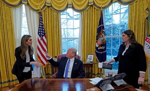 U.S. President Donald Trump confers with White House Communications Director Hope Hicks (L) as White House Press Secretary Sarah Sanders (R) listens during an interview with Reuters at the White House in Washington, U.S., January 17, 2018. PHOTO BY REUTERS/Kevin Lamarque