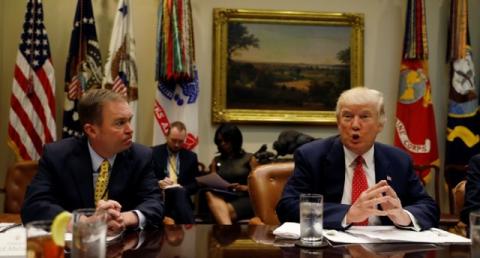 Director of the Office of Management and Budget Mick Mulvaney (L) listens to U.S. President Donald Trump speak during a "strategic initiatives" lunch at the White House in Washington, U.S., February 22, 2017. PHOTO BY REUTERS/Kevin Lamarque