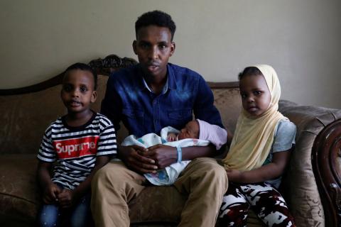 Aden Hussein Hassan with his daughter Asmo, 2 days, son Mohammed, 4, and daughter Adno, pose for a picture inside their apartment in Columbus, Ohio, U.S., August 8, 2018. PHOTO BY REUTERS/Shannon Stapleto