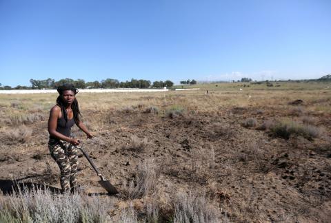 Noluthando Mswane gestures as she uses a spade to mark vacant land in Olievenhoutbosch near Centurion, South Africa, March 12, 2018. PHOTO BY REUTERS/Siphiwe Sibeko