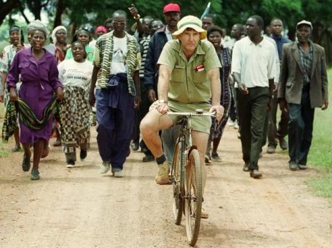 Zimbabwean commercial famer Tommy Bayley rides an old bicycle to an abandoned house to use as temporary shelter ahead of war veterans and villagers who invaded his farm Danbury Park in Maze, April 8, 2000. PHOTO BY REUTERS/Howard Burditt