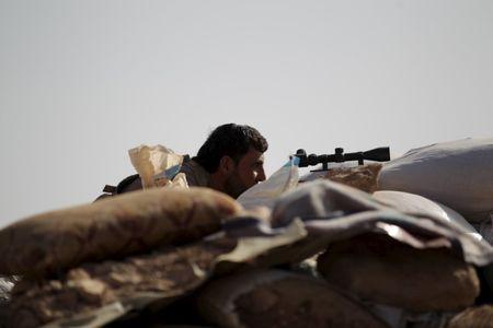A Free Syrian Army fighter of the 101 Division takes a position behind sandbags near the town of Morek in the northern countryside of Hama, Syria, October 14, 2015. PHOTO BY REUTERS/Khalil Ashawi
