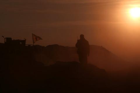 A Syrian Democratic Forces (SDF) fighter stands near a flag in northern Raqqa province, Syria, February 6, 2017. PHOTO BY REUTERS/Rodi Said