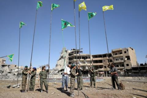 Fighters of Syrian Democratic Forces place flags at Naim Square after liberating Raqqa, Syria October 18, 2017. PHOTO BY REUTERS