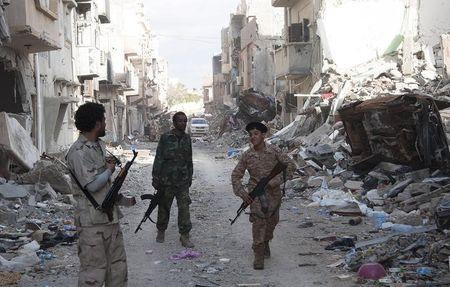 Members of Libyan pro-government forces, backed by the locals, walk with weapons during clashes in the streets with Shura Council of Libyan Revolutionaries, an alliance of former anti-Gaddafi rebels who have joined forces with Islamist group Ansar al-Sharia, in Benghazi, April 1, 2015. PHOTO BY REUTERS/Stringer
