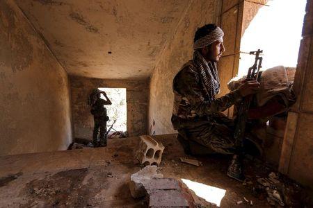 Kurdish People's Protection Units (YPG) fighters take up positions inside a damaged building in al-Vilat al-Homor neighborhood in Hasaka city, as they monitor the movements of Islamic State fighters who are stationed in Ghwayran neighborhood in Hasaka city, Syria, July 22, 2015. PHOTO BY REUTERS/Rodi Said