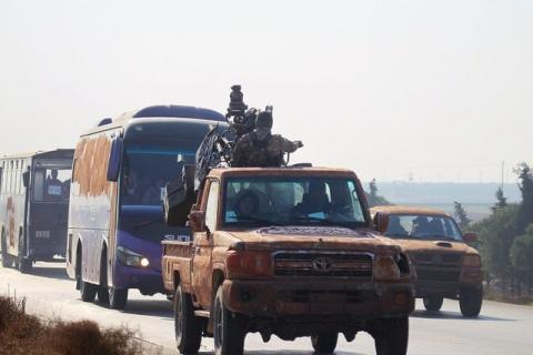 Fighters from a coalition of rebel groups called "Jaish al Fateh", also known as "Army of Fatah" (Conquest Army), escort buses evacuating fighters and civilians from the two besieged Shi'ite towns of al-Foua and Kefraya in the mainly rebel-held northwestern province of Idlib, Syria, December 28, 2015. PHOTO BY REUTERS/Ammar Abdullah
