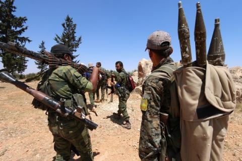 Fighters of the Syria Democratic Forces (SDF) carry their weapons as they walk in the western rural area of Manbij, in Aleppo Governorate, Syria, June 13, 2016. PHOTO BY REUTERS/Rodi Said