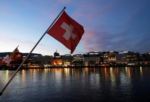 A Swiss flag is pictured during the sunrise on the Commercial and Financial District in Geneva, Switzerland, November 23, 2017. PHOTO BY REUTERS/Denis Balibouse
