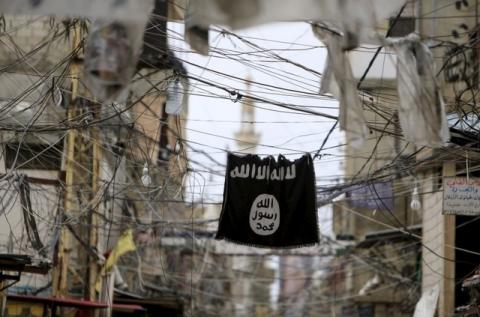 An Islamic State flag hangs amid electric wires over a street in Ain al-Hilweh Palestinian refugee camp, near the port-city of Sidon, southern Lebanon, January 19, 2016. PHOTO BY REUTERS/Ali Hashisho