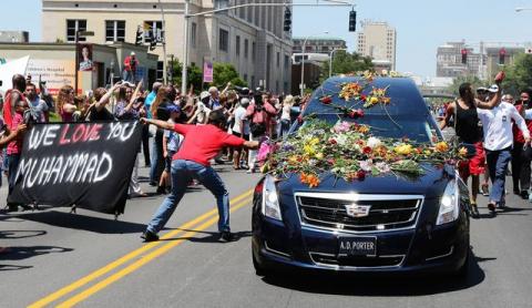 A man reaches out to touch the hearse carrying the body of Muhammad Ali as it drives down Broadway toward Cave Hill Cemetery in Louisville, Kentucky, U.S., June 10, 2016. PHOTO BY REUTERS/Michael Clevenger