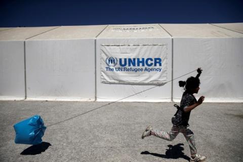A girl plays with a plastic bag as she runs past a United Nations High Commissioner for Refugees (UNHCR) tent, at a camp for refugees and migrants in Schisto, near Athens, Greece, April 26, 2016. PHOTO BY REUTERS/Alkis Konstantinidis