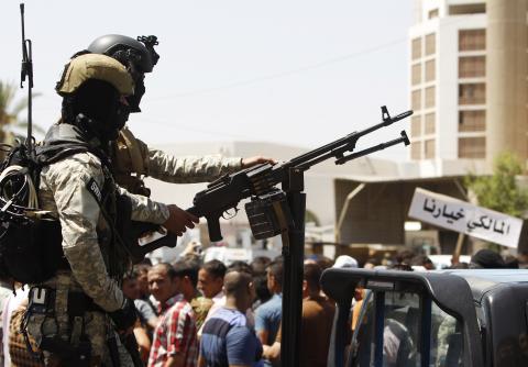 Iraqi policemen stand guard during a rally in support of Iraqi Prime Minister Nuri al-Maliki in Baghdad