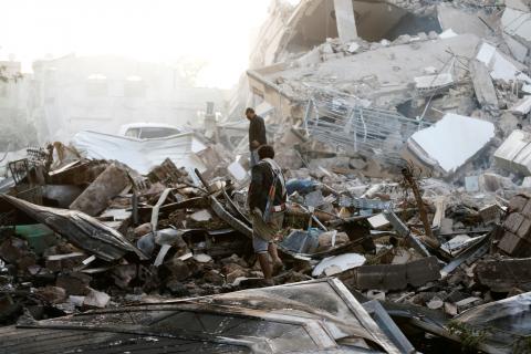 Guards walk on the wreckage of a building destroyed by air strikes in Sanaa, Yemen. PHOTO BY REUTERS/Khaled Abdullah