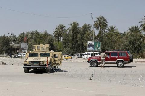 Iraqi security forces stand guard near the site of a suicide attack, which was targeting a checkpoint, in Baghdad April 4, 2016. PHOTO BY REUTERS/Ahmed Saad