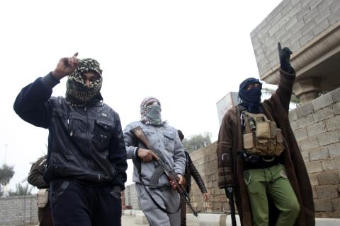 Gunmen fighters walk in the streets of the city of Falluja, 50 km (31 miles) west of Baghdad