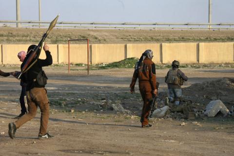 Masked Sunni Muslim gunmen take up positions with their weapons during a patrol in the city of Falluja, 70 km (44 miles) west of Baghdad
