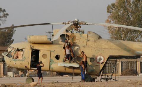 People take a picture on a damaged helicopter in Deir al-Zor airport, Syria, September 20, 2017. PHOTO BY REUTERS/Omar Sanadiki