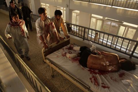 Afghan men carry a wounded man at a hospital after a bomb blast in northern Mazar-i-Sharif, Afghanistan, October 12, 2016. PHOTO BY REUTERS/Anil Usyan