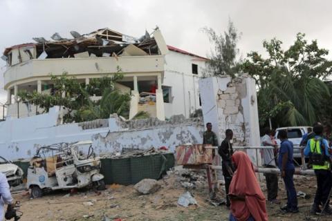 People stands outside the scene of an attack on a hotel and an adjacent restaurant in Mogadishu, Somalia, June 15, 2017. PHOTO BY REUTERS/Stringer