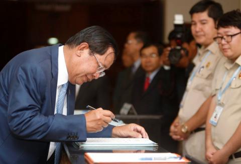 Cambodia's Prime Minister Hun Sen (L) signs a register as he arrives before a plenary session at the National Assembly of Cambodia, in central Phnom Penh, February 20, 2017. PHOTO BY REUTERS/Samrang Pring