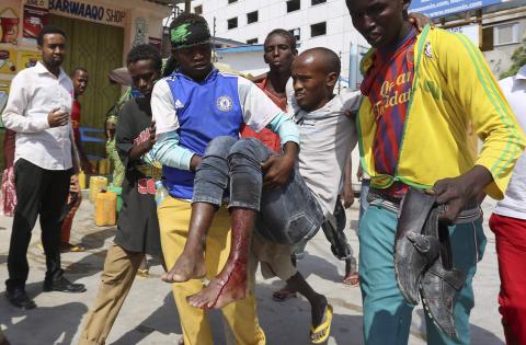 Residents evacuate a civilian injured in a car bomb explosion near the Taleex junction of Somalia's capital Mogadishu, January 2, 2015. PHOTO BY REUTERS/Feisal Omar