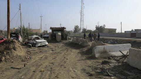 Iraqi security forces inspect the site of bomb attacks at a police station in Ramadi, 100 km (62 miles) west of Baghdad