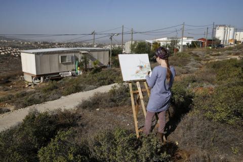 Hanna Horowitz, an Israeli resident of the Jewish settler outpost of Amona in the West Bank, draws a picture of the landscape in front of a caravan, December 5, 2016. PHOTO BY REUTERS/Baz Ratner