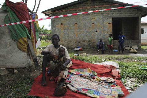 Suspected carrier of Ebola virus James Flomo sits in isolation with his children after his wife Lorpu Flomo died three days earlier in Monrovia, Liberia, January 21, 2015. PHOTO BY REUTERS/James Giahyue
