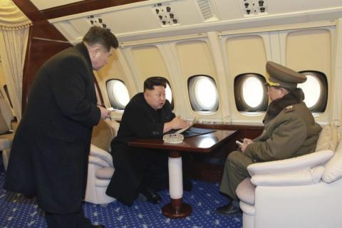 North Korean leader Kim Jong Un (C) talks with officials onboard his personal plane in this undated photo released by North Korea's Korean Central News Agency (KCNA) in Pyongyang, February 15, 2015. PHOTO BY REUTERS/KCNA