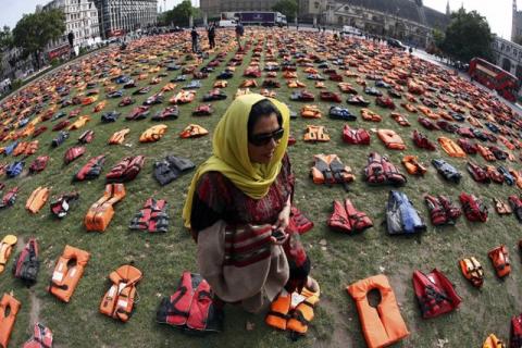Rehab Sidiqi, a trustee of Woman for Refugee Woman and originally from Afghanistan, poses for a photograph among 2500 lifejackets worn by refugees during their crossing from Turkey to the Greek island of Chois, in Parliament Square in central London, Britain, September 19, 2016. PHOTO BY REUTERS/Stefan Wermuth