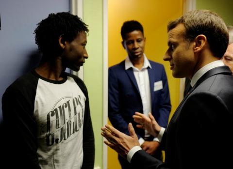 French President Emmanuel Macron talks to Ahmed Adam (L) from Sudan during his visit to a migrant center in Croisilles, northern France, January 16, 2018. At center is translator Elyas Ali, from Chad. PHOTO BY REUTERS/Michel Spingler