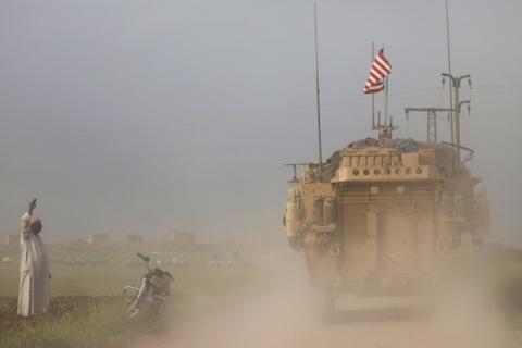 A man gestures at U.S military vehicles driving in the town of Darbasiya next to the Turkish border, Syria, April 28, 2017. PHOTO BY REUTERS/Rodi Said