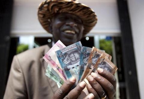 A man from South Sudan displays currency notes outside the Central Bank of South Sudan in Juba. PHOTO BY REUTERS/Benedicte Desrus