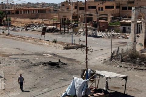 A man walks near a hole in the ground after an airstrike on Sunday in the rebel-held town of Dael, in Deraa Governorate, Syria, September 19, 2016. PHOTO BY REUTERS/Alaa Al-Faqir