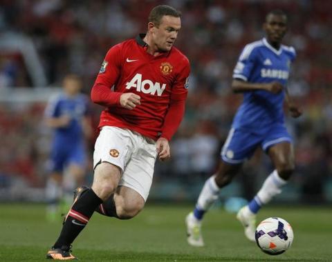 Manchester United's Wayne Rooney (L) runs with the ball