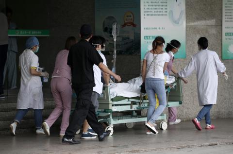 Medical personnel transport a victim of a factory explosion, at a hospital in Kunshan, Jiangsu province