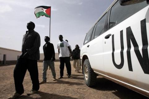 African would-be immigrants walk past a UN vehicle in the Bir Lahlu refugee camp in the Western Sahara. PHOTO BY REUTERS/Juan Medina