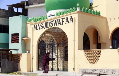 A woman stands outside the Masjid Swafaa mosque after policemen conducted a raid in the Kisauni area of the Kenyan coastal city of Mombasa, November 19, 2014. PHOTO BY REUTERS/Joseph Okanga