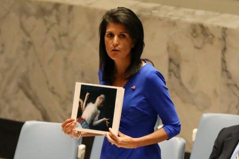 U.S. Ambassador to the United Nations Nikki Haley holds photographs of victims during a meeting at the United Nations Security Council on Syria at the United Nations Headquarters in New York City, NY, U.S., April 5, 2017. PHOTO BY REUTERS/Shannon Stapleton
