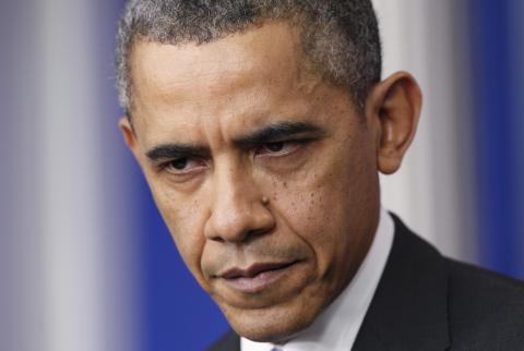 President Barack Obama pauses during his his year-end news conference in the White House briefing room in Washington