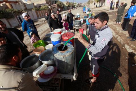 Iraqi people collect water in Mosul, Iraq, December 3, 2016. PHOTO BY REUTERS/Alaa Al-Marjani